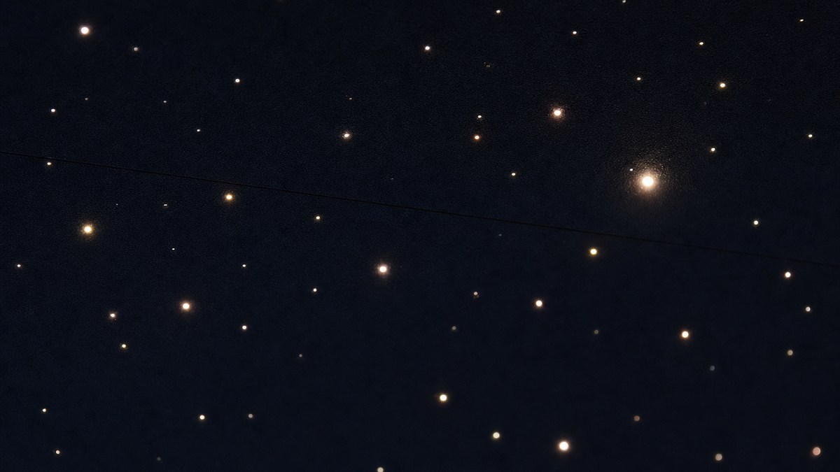 Close-up of a dark star ceiling panel surface with fiber optic star tips of different brightness glowing like a night sky